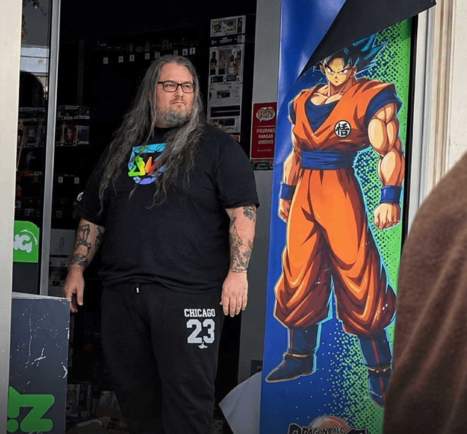 The viral photo: a store worker standing in the doorway next to a Goku poster during the riots in Nice